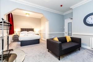 - une chambre avec un lit, un canapé et un réveil dans l'établissement St Mary's Apartments, à York