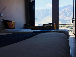 two beds in a room with a view of mountains at Mintu Home in Sapa