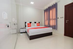 a bedroom with a bed with red pillows at Super OYO 106 Muscat Grand Hotel Apartment in Seeb