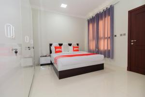 a bedroom with a bed with red pillows at OYO 106 Muscat Grand Hotel Apartment in Seeb