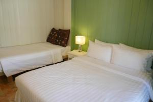 two beds in a room with a green wall at Banpu Koh Chang Resort in Ko Chang