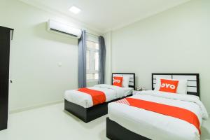 a bedroom with two beds and a window at Super OYO 106 Muscat Grand Hotel Apartment in Seeb