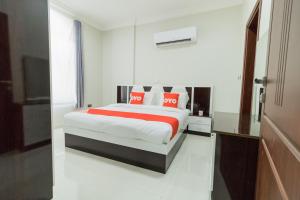 a bedroom with a bed with red and white pillows at OYO 106 Muscat Grand Hotel Apartment in Seeb
