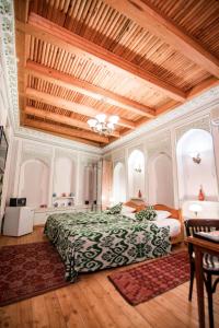Un dormitorio con una cama grande y un techo de madera. en Boutique Hotel Minzifa, en Bukhara