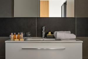 een badkamerbar met een wastafel en een spiegel bij Calarossa Bay Resort in Porto-Vecchio
