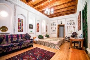 una sala de estar con un sofá y una mesa en Boutique Hotel Minzifa, en Bukhara