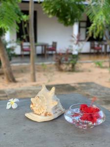 una mesa con concha y un tazón de flores en The Danish Villa Resort, en Arugam Bay
