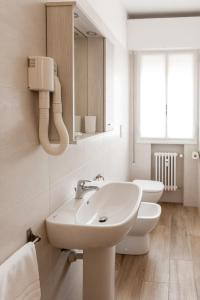 a white bathroom with a sink and a toilet at Appartamento Le Barche in Mestre