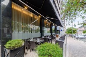 a restaurant with tables and chairs in front of a building at TURIM Marques Hotel in Lisbon