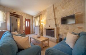 a living room with a blue couch and a fireplace at Kantouni House in Volimes