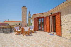 un patio con mesa y sillas y un edificio en Kantouni House en Volimai