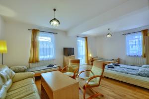 - un salon avec deux lits et un canapé dans l'établissement Centrum Noclegi, à Krynica-Zdrój