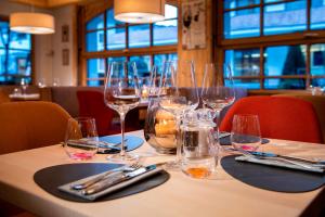 a table in a restaurant with wine glasses on it at MANNI das Hotel in Mayrhofen