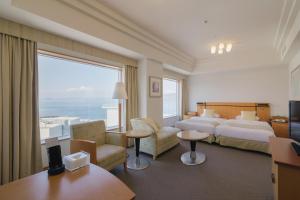 JR Hotel Clement Takamatsu في تاكاماتسو: غرفة فندقية بسرير ونافذة كبيرة