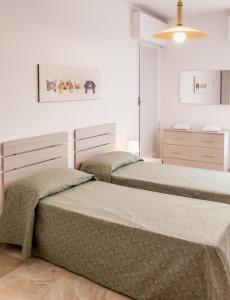 two beds in a bedroom with white walls at Appartamento Le Barche 2 in Mestre
