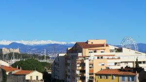 a view of a building with mountains in the background at Hotel Relais Du Postillon in Antibes