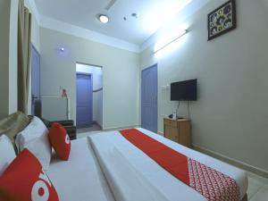 a bedroom with a large bed and a television at Super OYO 108 Marsa Al Masafar Hotel Apartment in Sur