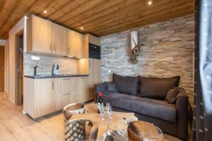 sala de estar con sofá y mesa en Résidence La Forêt du Praz - Courchevel 1850 en Courchevel