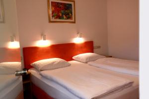 two beds in a room with lights on the wall at Mariaweiler Hof in Düren - Eifel