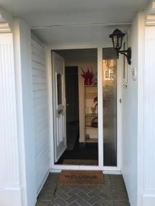 a door to a porch with a welcome sign on it at Cozy Homestay in Croydon