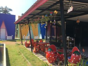a covered patio with red chairs and a train at Bangkado Resort in Ratchaburi