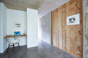 a room with a white chair and a wooden wall at ipartment Cologne Muelheim in Cologne
