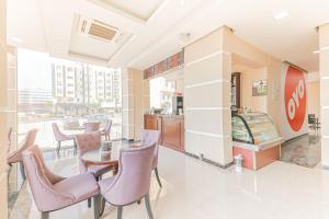 a restaurant with chairs and a table and a counter at Alpha Suites Hotel in Salalah