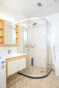 y baño con ducha y lavamanos. en Guangzhou Pengman Apartment Zhengjia Huanshi Branch, en Guangzhou