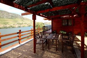 a patio with a table and chairs next to a river at Douro Yacht Charter & Bungalows in São João da Pesqueira