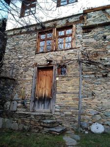 an old stone building with a wooden door and windows at Leshten Eco Villas in Leshten