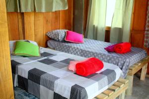Dos camas con almohadas de colores en una habitación. en Morada da Laika, en Praia do Rosa 97 fotos más