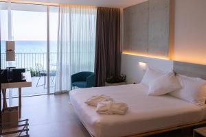 a hotel room with a bed with towels on it at Posia Retreat & Spa UNA Esperienze in San Foca