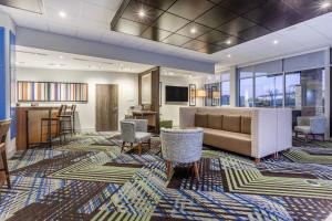 a lobby with a couch and chairs and a bar at Holiday Inn Express & Suites - Florence - Cincinnati Airport, an IHG Hotel in Florence