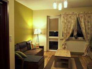 uma sala de estar com um sofá e uma janela em Apartamenty Silver Premium em Varsóvia