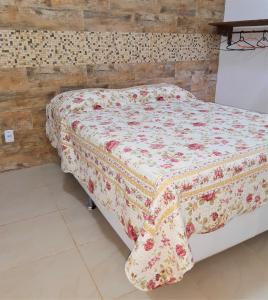 a bed with a quilt on it in a bedroom at Casa Caiada - Suites in Abraão