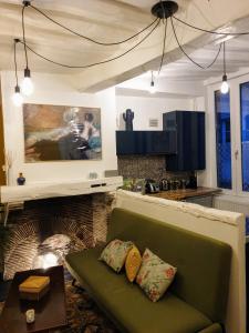 uma sala de estar com um sofá verde em frente a uma lareira em Maison hypercentre Rouen tout confort em Rouen