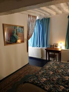 a bedroom with a bed and a table and a window at Maison hypercentre Rouen tout confort in Rouen
