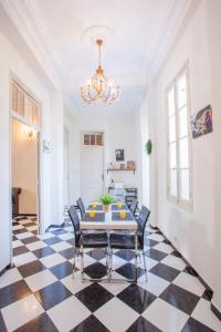 a dining room with a table and chairs on a checkered floor at appartement haussmannien centre ville Casablanca in Casablanca