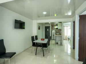 uma sala de jantar e sala de estar com mesa e cadeiras em ApartaHotel Luxury em Paipa