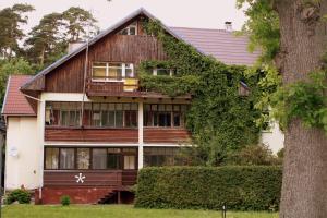 een huis met klimop aan de zijkant bij Neringarent DRUSKĖ - 2-jų miegamųjų su atskiru įėjimu in Juodkrantė