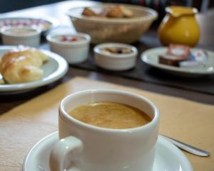 a cup of coffee on a table with plates of food at CasaGrande Hotel in Chilecito