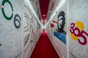um corredor com graffiti nas paredes e um tapete vermelho em Platforma Design Hotel em Tbilisi
