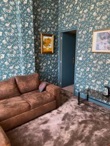 een woonkamer met een bank en een blauwe muur bij Le Castel Ecossais in Senlis