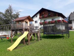 a playground with a slide and a house at Schusterbauernhof in Bad Mitterndorf