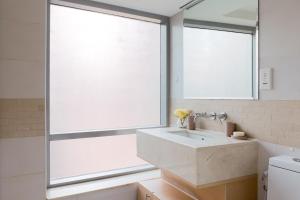 a bathroom with a sink and a large window at Nasma Luxury Stays - Pastel-Colored Apt With Jaw-Dropping Marina Views in Dubai