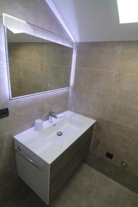 a bathroom with a white sink and a mirror at SeaHouse 114 in Mali Lošinj