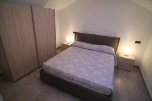 a small bedroom with a bed and two night stands at SeaHouse 114 in Mali Lošinj