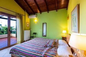 una camera con un letto con una parete verde di Diktamos Villas ad Atsipópoulon