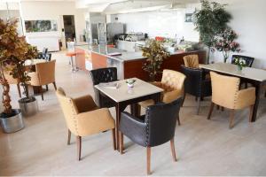 a restaurant with tables and chairs and a kitchen at Arsan Otel in Kahramanmaraş