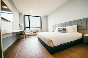 a bedroom with a large bed and a large window at Chill Suites Langkawi in Kuah